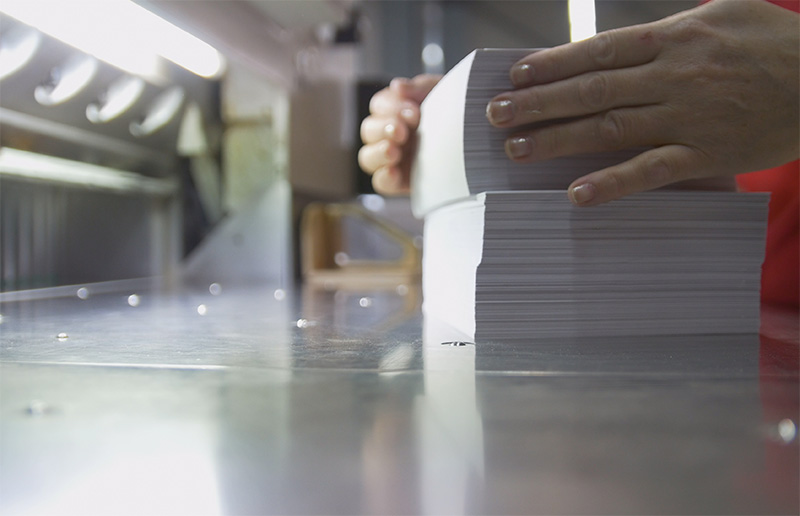 印刷した紙の束を整えている