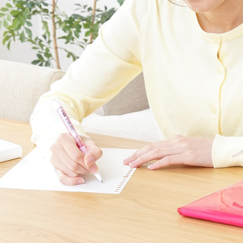 紙に原稿を書いている女性